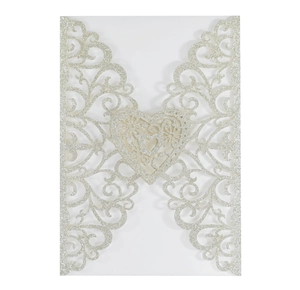 Detail of silver glitter wedding invitation with laser-cut hollow heart and floral patterns