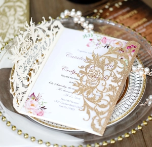 Detailed laser cut rose wedding invitation on an elegant glass plate with a floral insert