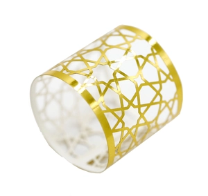 Detailed close-up of golden metal napkin ring with hollow geometric star pattern