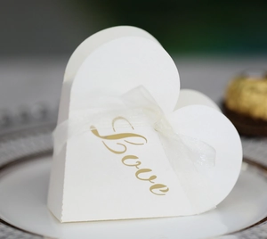 Detail of white matte favor box with golden Love foil stamping and sheer organza ribbon