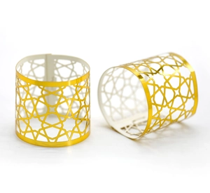 Detailed macro view of two gold laser-cut napkin rings with geometric star patterns