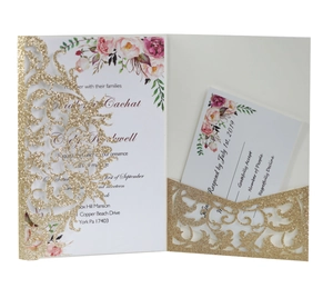 Detail of laser cut glitter gold wedding invitation with floral insert and RSVP card
