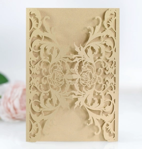 Detail of laser-cut rose patterns on champagne gold pearlescent wedding invitation paper