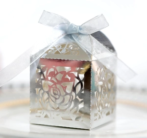 Detailed laser-cut silver candy box with rose patterns and a light blue silk bow