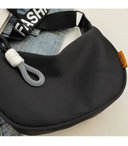 Detail of black crescent canvas bag with fashion webbing strap and white rope accents