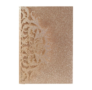 Macro detail of laser-cut vine patterns on rose gold glitter wedding invitation card