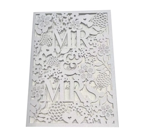 Macro view of laser-cut Mr & Mrs wedding card with floral patterns and glitter inner