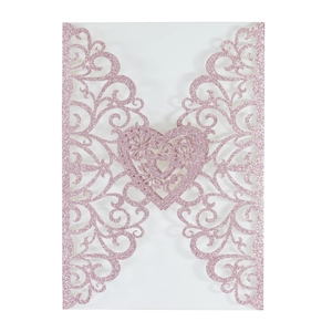 Detail of pink glitter laser cut wedding invitation card featuring intricate floral patterns