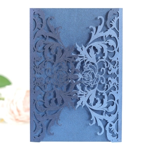 Detail of laser-cut rose patterns on pearlescent navy blue wedding invitation card