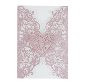 Detail of pink glitter laser-cut lace invitation with intricate floral heart pattern