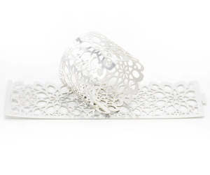Close-up of white laser-cut napkin ring with intricate mandala floral hollow design