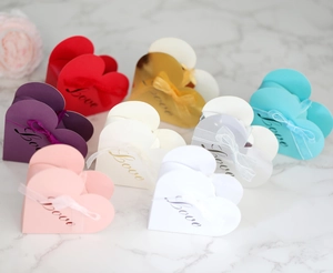 Close-up of heart-shaped gift boxes with silk ribbons and Love lettering in various colors