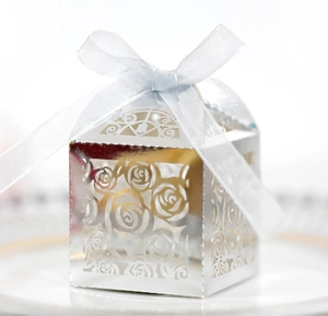 Detail of silver laser-cut rose hollow candy box with light blue satin ribbon bow