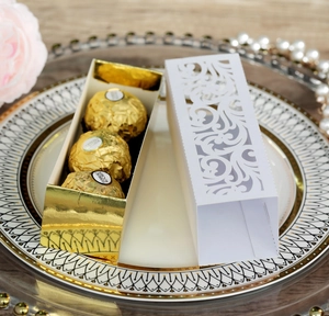 Détail de boîte cadeau de mariage dorée découpée au laser pour chocolats et truffes