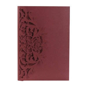 Detailed laser-cut rose and floral pattern on burgundy pearlescent wedding invitation