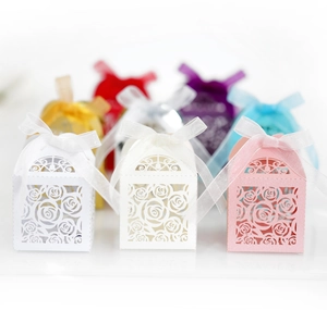 Macro detail of laser-cut rose hollow gift box with satin ribbon for wedding favor