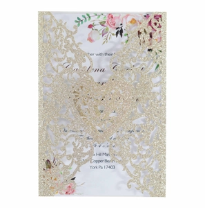 Macro detail of laser-cut glitter wedding invitation with heart and butterfly pattern