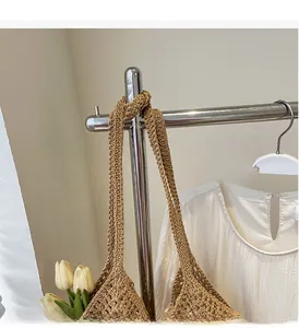 Detail of hand-woven straw tote bag with wide shoulder strap and natural crochet texture