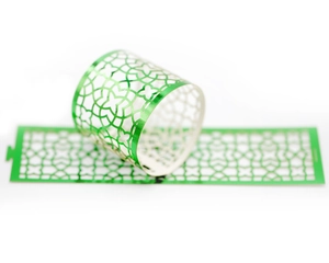 Macro view of green laser-cut hollow floral napkin ring with geometric pattern
