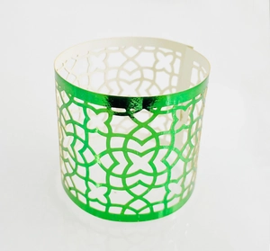 Detailed macro view of the intricate laser-cut hollow pattern on a green napkin ring