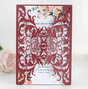 Detail of laser-cut burgundy rose invitation card with floral interior and elegant carving