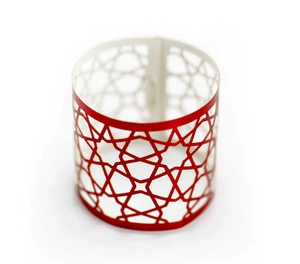 Close-up of laser-cut red napkin ring with star geometric pattern for wedding decor