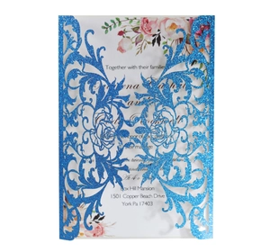 Detail of laser-cut blue glitter wedding invitation with delicate floral inner card