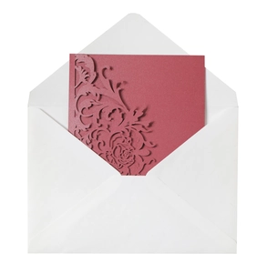 Close-up of laser-cut floral wedding invitation card with premium white envelope