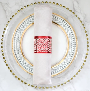 Elegant red hollow geometric napkin ring with metallic finish on white satin napkin