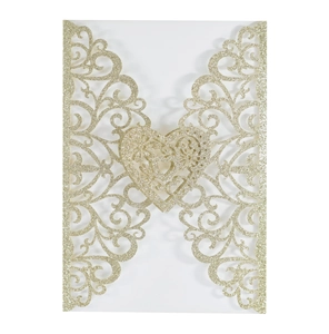 Macro view of gold glitter laser-cut wedding invitation with intricate heart vine patterns