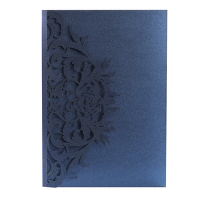 Detailed laser-cut navy blue pearlescent paper invitation with intricate floral patterns