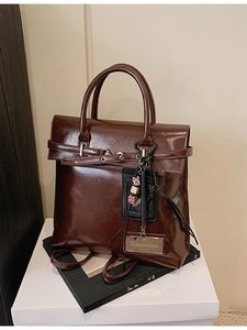 Retro dark brown polished leather backpack with double handles and decorative charms