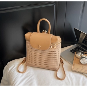 Detail of hollow woven straw backpack with premium leather flap and gold hardware