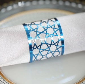 Close-up of blue geometric hollow-out napkin ring with metallic luster on white fabric