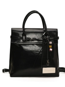 Elegant black glossy leather backpack for women with silver metal buckles and charms