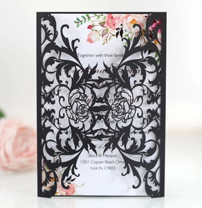 Laser cut black invitation cover with intricate rose vine pattern and floral inner card