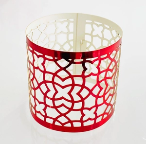 Macro detail of red metallic laser-cut cupcake wrappers with geometric floral hollow pattern