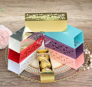 Détails de boîtes cadeaux dorées découpées au laser avec motifs de vigne pour bonbons
