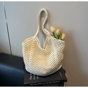 Detail of hand-crocheted beige tote bag with hollow woven texture and long shoulder strap