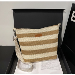 Detail der geflochtenen Beuteltasche mit Streifenmuster und breitem Ethno-Schultergurt