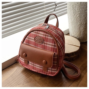 Detail view of retro red plaid mini backpack with brown leather trim and fashion logo