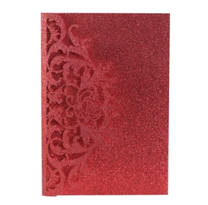 Macro detail of red glitter paper laser cut wedding invitation with floral patterns