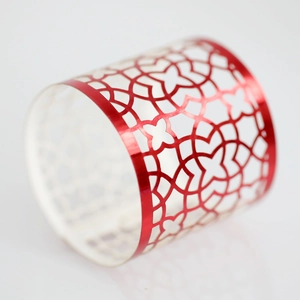Macro shot of red metallic napkin ring with laser-cut geometric floral hollow design