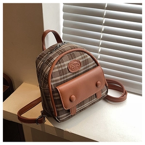 Detail of vintage plaid mini backpack with leather texture and 'Fashion' logo patch