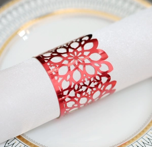 Macro detail of laser-cut red hollow napkin ring with floral mandala pattern