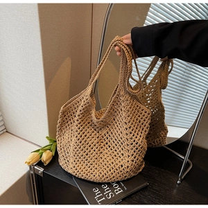 Detailed close-up of khaki handmade woven hollow tote bag texture and long shoulder straps