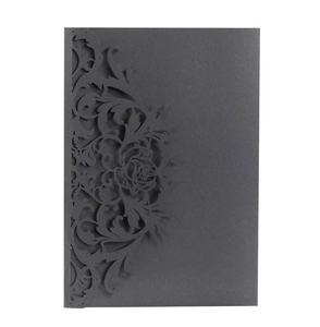 Detail of laser-cut rose patterns on elegant black matte paper for wedding invitations