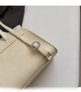 Detailed macro view of silver metallic buckle and premium leather texture on beige bag