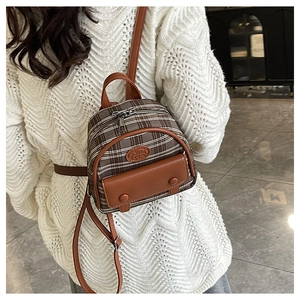 Detailed back view of a mini vintage plaid backpack on a white sweater model