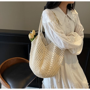 Detailed close-up of a cream woven tote bag with intricate mesh patterns and shoulder strap